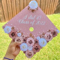 someone is holding up a pink graduation cap with flowers on the front and side, that says i did it class of 202