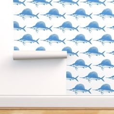 a wall with blue fish on it next to a roll of toilet paper