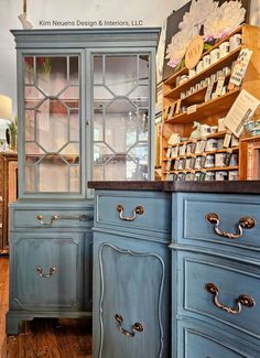 a blue cabinet with glass doors and drawers