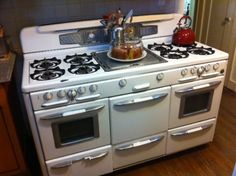 a white stove top oven sitting inside of a kitchen