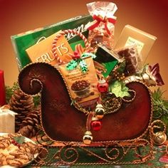 a christmas sleigh filled with cookies, candy and other holiday treats on a table