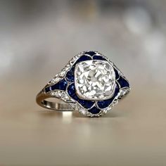 an antique diamond and blue enamel ring with diamonds in the center, on a table