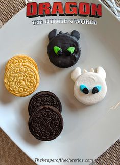 four decorated cookies on a white plate with the title'dragon the hidden world '