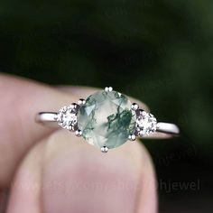 "This is a moss agate engagement ring in solid gold,about 7mm round cut. The accent stones are round 3mm moissanites. It can be made in any ring size. However please contact me to custom make it to a special big or small size. It can be made in white gold,rose gold or yellow gold with 14k or 18k. However for some people who are nickel allergic,I can also make it to 925 sterling silver to make you can wear it. The ring is handmade,very high quality! 30 days money back guarantee. Returns & War Rose Gold Moissanite Ring, Gold For Women, Engagement Ring Moissanite, Moss Agate Engagement Ring, Agate Engagement Ring, Moss Agate Ring, Jewelry Dainty, Three Stone Ring, Ring Moissanite