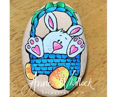 a painted rock with an easter bunny in a basket