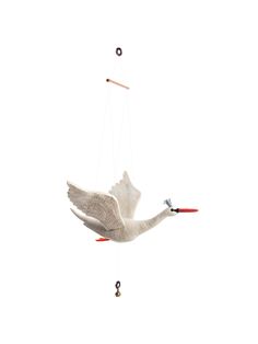 a white bird flying through the air with a red beak and long legs hanging from it's wings