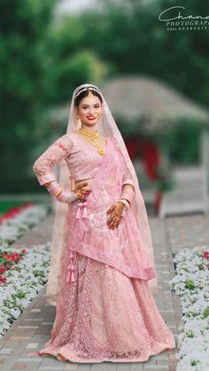 a woman in a pink bridal gown posing for the camera