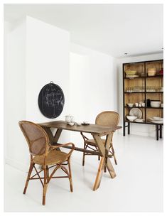 a dining room table with chairs and a chalkboard on the wall