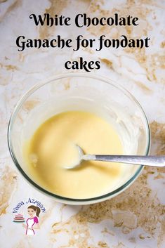 a white chocolate ganache for fondant cakes in a glass bowl with a spoon