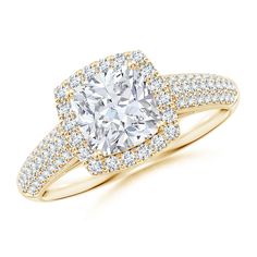 a yellow gold engagement ring with a cushion cut diamond surrounded by pave diamonds