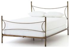 a metal bed frame with white sheets and pillows on it's headboard, against a white background