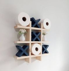 a wall mounted shelf with toilet paper and vases on it