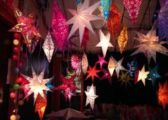 many different colored stars hanging from the ceiling