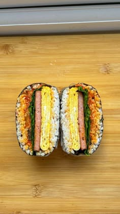 two sub sandwiches with different toppings on a cutting board