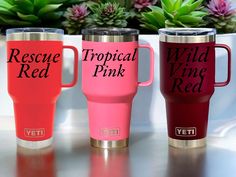 three travel mugs with the words rescue pink, wild pink and yeti on them