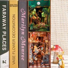 three books are stacked on top of each other with figurines in front of them