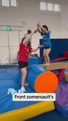 two girls are standing on top of an inflatable trampoline while another girl holds her hands up