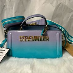 This Is A Brand New With Tag Steve Madden Teal And Purple Ombre Bevie-O Double Strap Logo Crossbody Satchel Bag With Air Pod/Coin Case. All Zippers, Clasps And Snaps Intact And Working. This Is A Smoke And Pet Free Home. Teal And Purple Ombre Bag. Steve Madden Logo Across The Front. Teal Top Handle. Gold-Tone Hardware. Double Compartments. Top Magnetic Snap Closure And Zipper Closure. Removable, Adjustable Logo, Crossbody Strap. Removable, Adjustable Teal Strap. Lined Interior With A Zipper Pock Blue Pouch Box Bag For Mobile Phone, Blue Mobile Phone Pouch Box Bag, Modern Blue Shoulder Box Bag, Modern Blue Box Bag For Shopping, Modern Blue Satchel Box Bag, Trendy Blue Box Bag, Blue Pouch Box Bag For Shopping, Blue Box Bag Pouch For Shopping, Blue Box Bag For Shopping