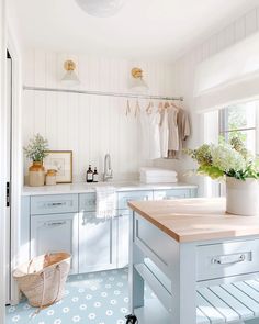 a kitchen with white cabinets and blue flooring is pictured in this image, there are flowers on the counter