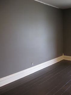 empty room with hard wood floors and gray walls