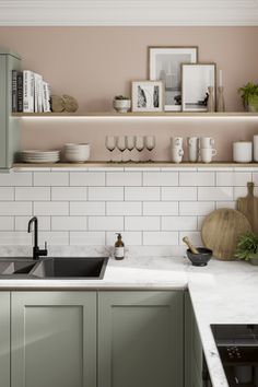 a kitchen with green cabinets and marble counter tops, white subway backsplash and open shelving