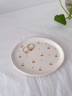 two wedding rings on a plate with cherries