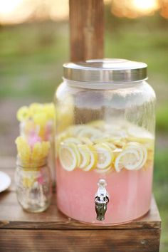 a mason jar filled with lemons and water sitting on top of a wooden table