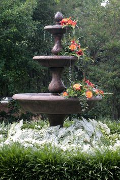 three tiered fountain with flowers in the middle