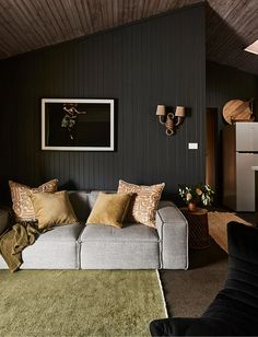 a living room filled with furniture and decor on top of a wooden floor covered in rugs