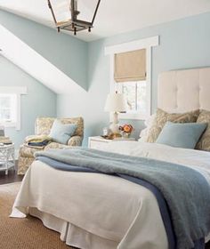 a bedroom with blue walls and white furniture