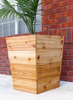 a wooden planter sitting next to a brick wall