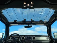 the interior of a vehicle with its sunroof and dash lights on, as seen from inside