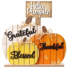 two wooden pumpkins with the words grateful and thankful