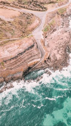 an aerial view of the ocean and road