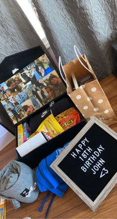 a birthday gift box is sitting on the floor next to a bag and other items