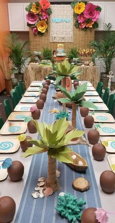 a table set up for a party with plates and place settings on it, including palm trees