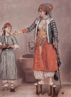 two women standing next to each other in front of a sink with a bowl on it