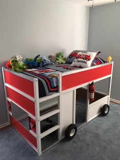 a red and white bunk bed sitting on top of a carpeted floor next to a wall