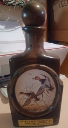 a bottle with a bird on it sitting on a table