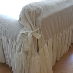 a bed with a white ruffled bedspread on it