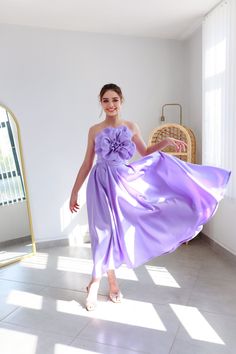 a woman in a purple dress posing for the camera