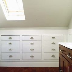 an empty room with many drawers and a skylight