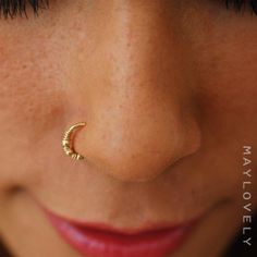 a close up of a woman's nose with a gold nose ring on it