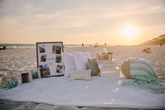 a bed on the beach with pillows and pictures