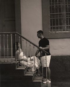 a man and woman are standing on the stairs