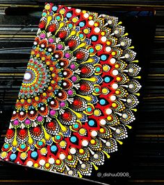 an intricately designed notebook with colorful designs on the cover is sitting on a black surface