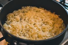 a pan filled with noodles sitting on top of a stove