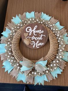 a wreath made out of burlocks and ribbon with the words home sweet home on it