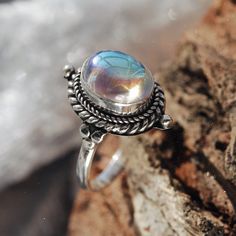 Stand out from the crowd with our boho chic iridescent mystic opal sterling silver ring. Our Little Luna is a beautiful ring with delicate detailing featuring an enchanting witchy mystic stone centre. A Shop Dixi classic to enhance your bohemian jewellery collection. MaterialSterling SilverSynthetic Mystic Opal SizingRing Front - Height 18mm Magical Adjustable Silver Crystal Ring, Adjustable Silver Magical Style Rings, Adjustable Silver Mystical Crystal Ring, Mystical Silver Crystal Ring With Gemstone, Silver Crystal Ring With Gemstone, Mystical Silver Opal Ring, Spiritual Sterling Silver Opal Ring, Mystical Silver Crystal Ring, Bohemian Silver Sterling Silver Opal Ring