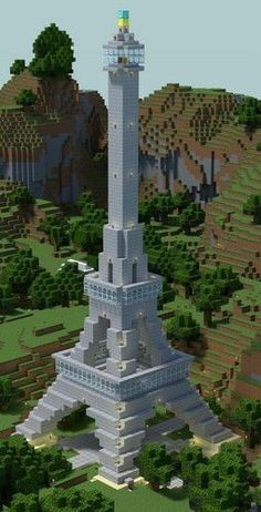 a large white tower sitting on top of a lush green field next to a forest